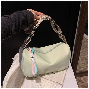 Détail du sac cylindrique vert menthe avec bandoulière large à motifs géométriques