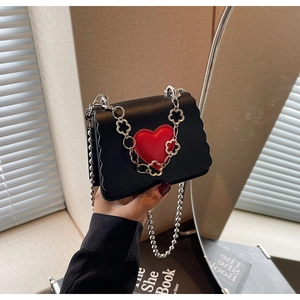 Mini black crossbody bag with red heart detail and decorative silver ball chain