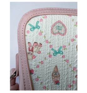 Detail of pink leather trim and floral bow pattern on sweet ballet crossbody bag