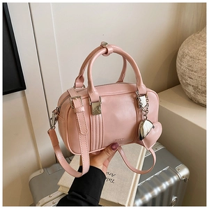 Detail of pink leather bowling bag with heart charm and adjustable shoulder strap