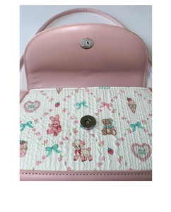 Detail of pink bow bag interior featuring cartoon embroidery and silver magnetic closure