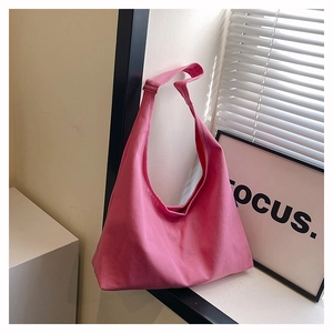 Detailed close-up of a pink canvas hobo shoulder bag in a minimalist lifestyle setting