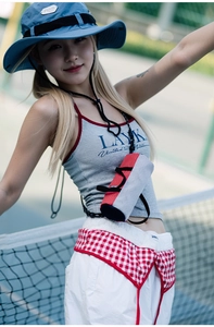 Outdoor sporty lifestyle view of a red and grey nylon cylinder crossbody bag for women