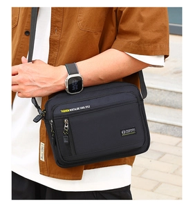 Seitenansicht eines Mannes mit schwarzer Multi-Pocket Umhängetasche aus Nylon im Streetstyle
