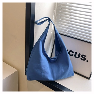 Close-up of a blue large-capacity canvas tote bag on a windowsill for daily commuting