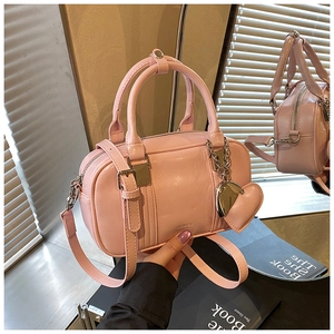 Pink bowling bag with heart pendant and ROSSK logo on warm lifestyle background