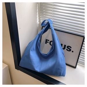 Detailed macro of thick blue canvas fabric on a minimalist high-capacity tote bag