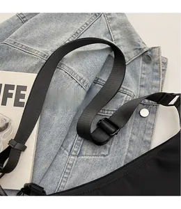 Detail of adjustable black nylon shoulder strap on a denim jacket for casual crossbody bag