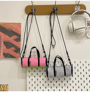 Close-up of mini sports crossbody bags with black handles and woven straps in a lifestyle setting