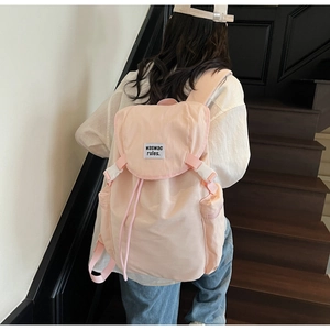Detail view of pink nylon backpack with drawstring closure and buckle for travel and school