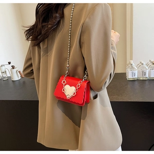 Model view of a mini red heart crossbody bag with wave edges and silver bead chain