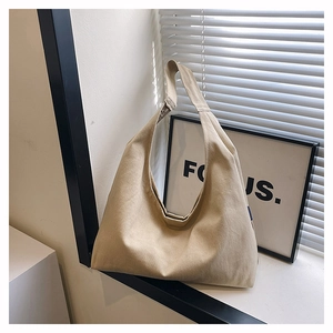 Close-up of khaki canvas hobo bag with wide shoulder strap in natural sunlight