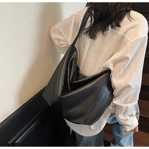 Minimalist large black leather hobo bag shown on shoulder for daily commute style