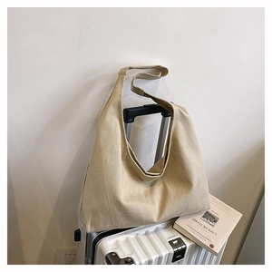 Detail of high-density canvas tote hanging on suitcase handle with natural texture