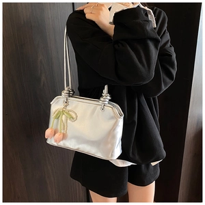 Detail of silver metallic tote bag with vintage clasp and pearl tulip floral pendant