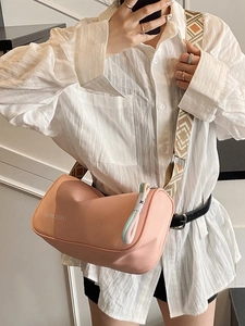 Sac bandoulière cylindrique rose avec large sangle géométrique et logo imprimé