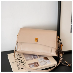 Détail du sac vintage en cuir ciré avec boucle dorée et ornement de bandoulière tressée