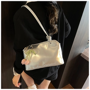 Dettaglio della borsa metallizzata argento con texture a pieghe e ciondolo a tulipano
