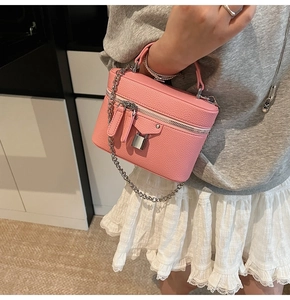Pink vanity bag with lychee texture featuring a silver padlock and chain strap detail