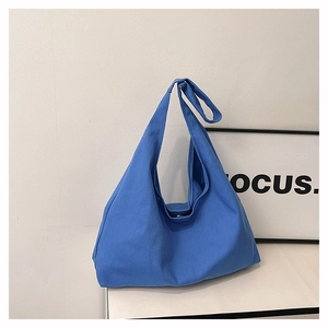 Macro detail of royal blue canvas tote bag fabric and minimalist hobo style design