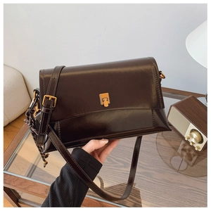 Détail du sac bandoulière vintage en cuir huilé avec boucle en métal doré élégante