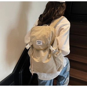 Detail of light khaki canvas backpack with contrast buckle and branded textile label