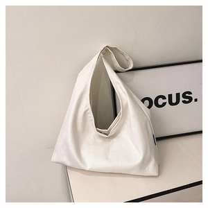Detailed close-up of a minimalist cream white canvas tote bag with magnetic metal snap closure