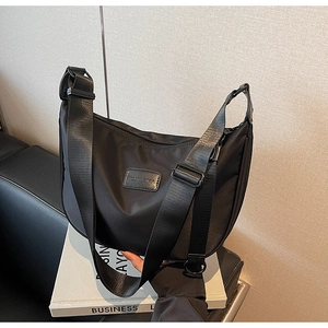 Detail of black nylon hobo bag with adjustable strap and Moonversa brand patch