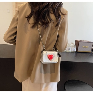 Detail of silver metallic mini bag with red heart accent and bead chain shoulder strap