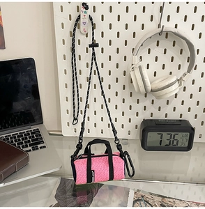 Macro detail of rose pink running crossbody bag showing zipper and adjustable strap