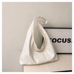 Detail of a large cream canvas hobo bag for commuting, showing the durable material and strap
