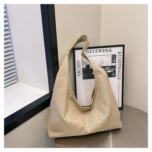 Close-up of beige canvas hobo tote bag texture on a modern silver metal table