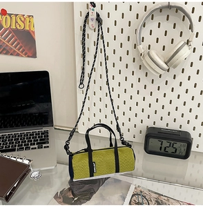 Detail of green nylon mini crossbody bag with rope strap on a modern tech lifestyle desk
