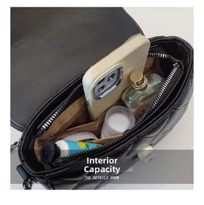 Internal capacity detail of black quilted shoulder bag with silver lock and inner pockets