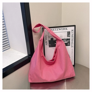 Minimalist pink canvas tote bag detail on metallic surface with modern background