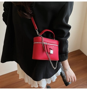Detail of red pebbled leather mini vanity bag with silver hardware and chain strap
