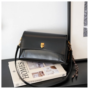Détail du petit sac carré en cuir ciré noir avec boucle métallique dorée élégante