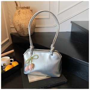 Detail of silver metallic handbag with unique cord handle and floral tulip charm decoration