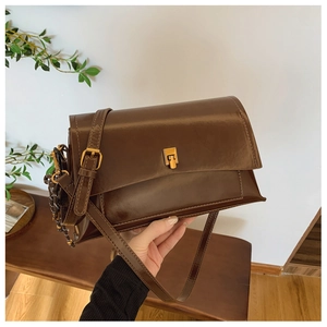 Détail du sac vintage en cuir huilé marron avec fermoir doré et pendentif tissé