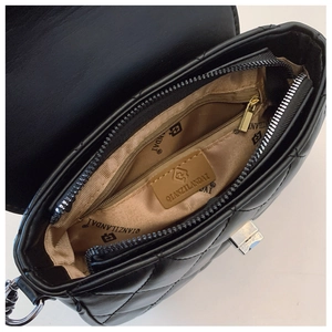 Detail view of the quilted bag interior showing golden lining and metal zipper pocket