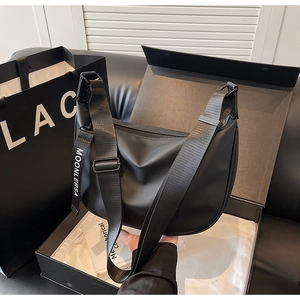 Detail of black crescent crossbody bag in luxury gift box with adjustable wide strap