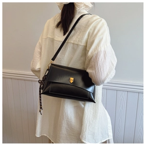 Détail du sac bandoulière en cuir ciré vintage avec un fermoir carré en métal doré