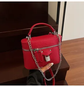 Detail of red lychee leather mini crossbody bag with silver chains and motorcycle style