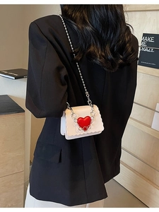 Mini cream crossbody bag with scalloped edges and red heart detail on silver bead chain