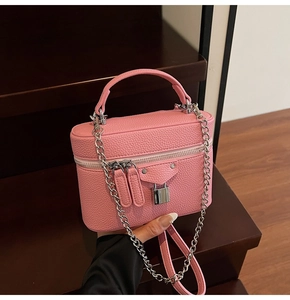 Detailed view of pink lychee texture leather crossbody bag with chain strap and metal lock