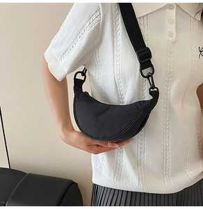 On-body view of large black nylon crescent crossbody bag with adjustable strap