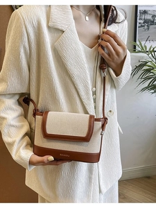 Chic beige canvas and brown leather crossbody bag styled with a white blazer