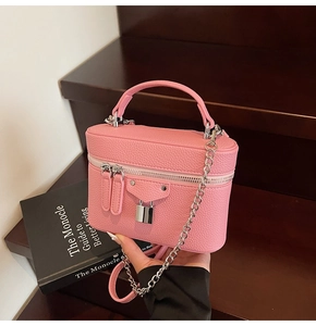 Detailed macro view of pink vanity case bag with leather texture and silver chain strap