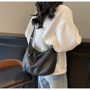 Detail of black nylon hobo bag with Moonlersa strap shown on model for capacity