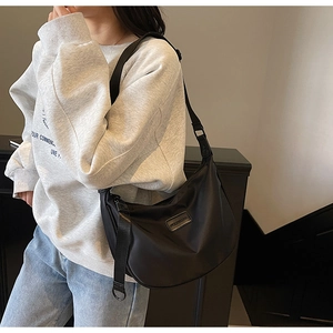 Side view of large black nylon crescent bag with adjustable wide shoulder strap